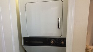 A compact laundry room with a white washer and dryer, a door, and a tiled floor. -  40 ft to the ocean 4 bd/3 bath ocean view beach house sleeps  (Myrtle Beach)