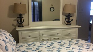 A bedroom with a bed, a dresser, two lamps, and a mirror. -  40 ft to the ocean 4 bd/3 bath ocean view beach house sleeps  (Myrtle Beach)