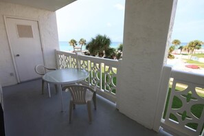 Enjoy a tranquil beachside retreat with a balcony featuring a round table and two chairs.