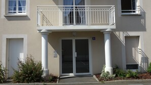 A two-story building with a balcony, a door with a glass panel, and a small window with a shutter. - Comfortable apartment, close to Perros-Guirec and Ploumanac'h beaches (Perros-Guirec)