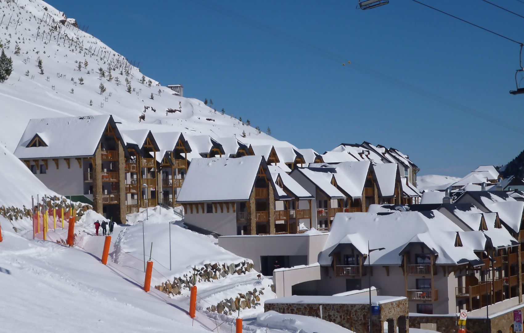 A snow-covered ski resort with wooden chalets and a ski lift.