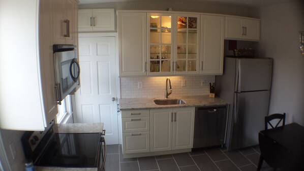 Enjoy cooking in this well-equipped kitchen with a stainless steel refrigerator, dishwasher, and microwave.