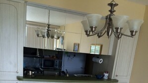A kitchen with a dining table and chairs, a chandelier, and a refrigerator. - Magnificent beach front condo with pool and restaurant/bar (Freeport)