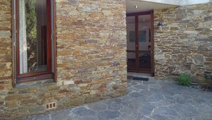 A stone building with a wooden door and window.