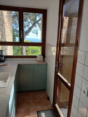Una cocina compacta con vistas a la vegetación y un paisaje lejano.