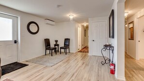 A hallway with wooden flooring, a white door, a black-framed mirror, and a chandelier. - View of the Yellowstone Valley  (Gardiner)