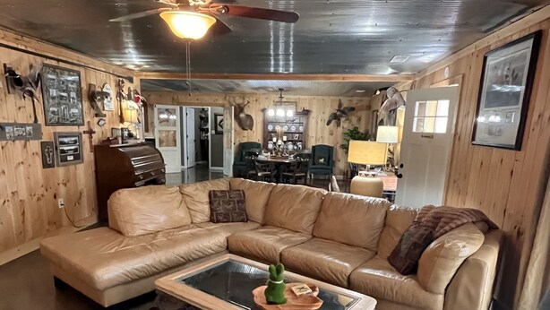 A cozy living room with a sectional sofa, a glass coffee table, and a cowhide rug.