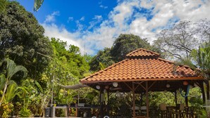 A pool area with a gazebo, surrounded by lush greenery and trees. - Pool, Sauna, Hot Tub, Fruit Trees, Lush Gardens (Atenas)