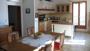 A kitchen with wooden cabinets, a built-in oven, and a dining area with a table set for two.