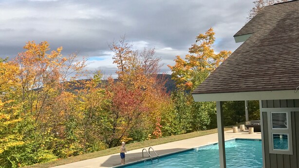 A swimming pool with a covered area, surrounded by trees with autumn foliage. - Sunday River Ski In Ski Out Locke Mountain condo with Pool Jacuzzi (Newry)