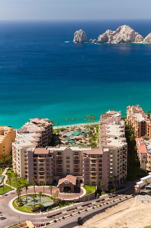 A coastal hotel with multiple buildings, a swimming pool, and a view of the ocean.