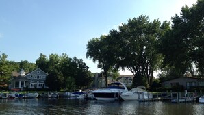 A marina with several boats docked, surrounded by residential houses and trees.