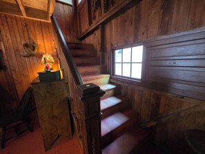 A wooden staircase with a lamp on a table, a window, and a door. - Detox Cottage ▪︎ BYO Linens & Unplug (Mount Gretna)