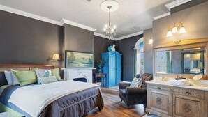 Un dormitorio con una cama grande, un aparador y un espejo.