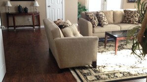 A living room with a sofa, a coffee table, and a rug. There is a door and a picture frame on the wall. - Beautiful 2 Bedroom Luxury Loft in the heart of Aurora (Aurora)