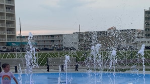 Een water speelplaats met verschillende fonteinen en een blauwe vloer.