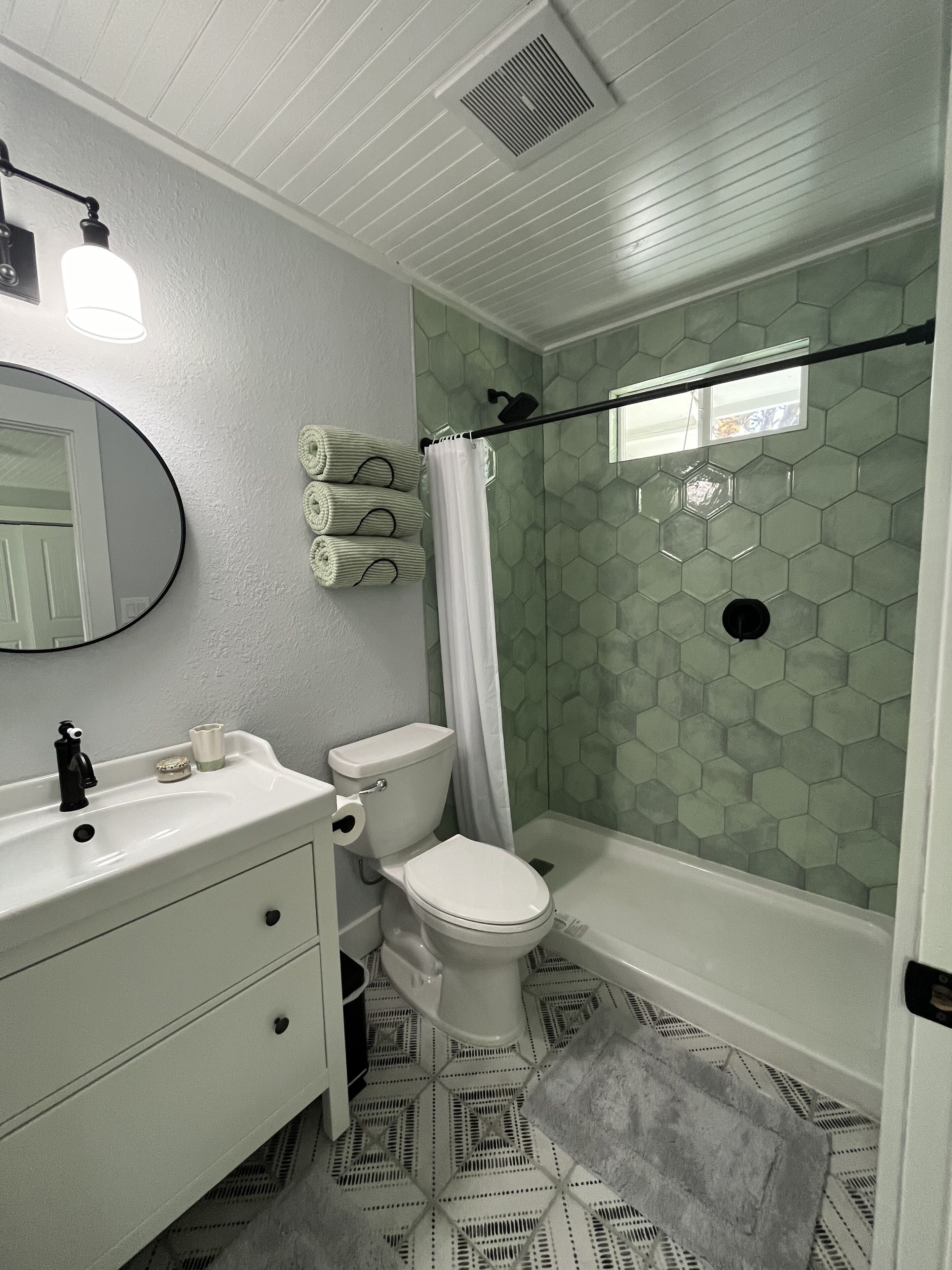 Un baño con inodoro, lavamanos y ducha.