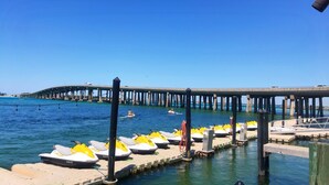 A pier with yellow and white jet skis docked at the end.