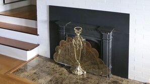 A white brick fireplace with a decorative mantel, a large mirror above it, and a set of stairs leading to a door. - SEQUIM HERITAGE HOUSE where relaxed elegance & craftsmanship abound....  (Sequim)