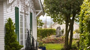 A white house with green shutters, a small garden with potted plants, and a stone pathway leading to the entrance. - SEQUIM HERITAGE HOUSE where relaxed elegance & craftsmanship abound....  (Sequim)