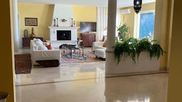 Een smart-tv, een open haard, een tafeltennistafel en boeken