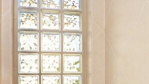 A bathroom with a large window featuring a geometric pattern. - 2BR 221: Sleeps 6, Bunks, Pool, Hot Tub, Sea Views (Placencia)
