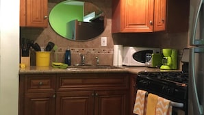 A kitchen with wooden cabinets, a stainless steel refrigerator, a stove, and a microwave. - Steps to the water on both sides!! (San Diego)