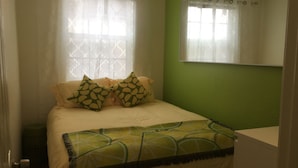 A bedroom with a bed, a green wall, a mirror, and a window with sheer curtains. - Steps to the water on both sides!! (San Diego)