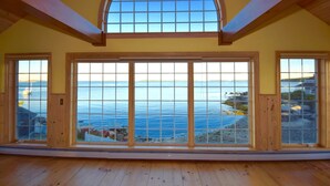 A room with large windows offering a view of the sea and a wooden ceiling. - Lobster Bill - Spruce Head Island, USA (South Thomaston)