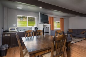 Un espacio habitable compacto con comedor, kitchenette y zona de estar.