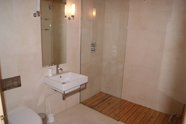 Une salle de bain avec un lavabo blanc, un miroir et des toilettes.