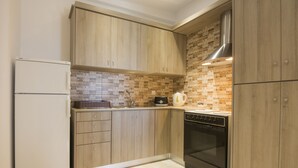 A kitchen with wooden cabinets, a refrigerator, a microwave, a toaster, and a coffee maker.