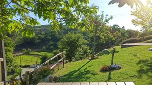 A wooden deck overlooking a grassy area with trees and a distant view of hills. - Nature in its purest state ... (Casais de Vide)