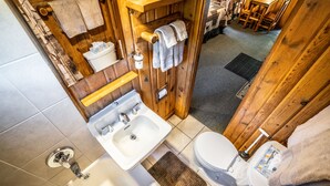Une salle de bain en bois avec un lavabo, des toilettes et une douche.