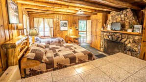 Une chambre de style rustique, avec un lit, une cheminée et un mur en pierre.