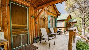Une cabane en bois avec un porche, un paillasson et une plaque indiquant le numéro de chambre : 4.