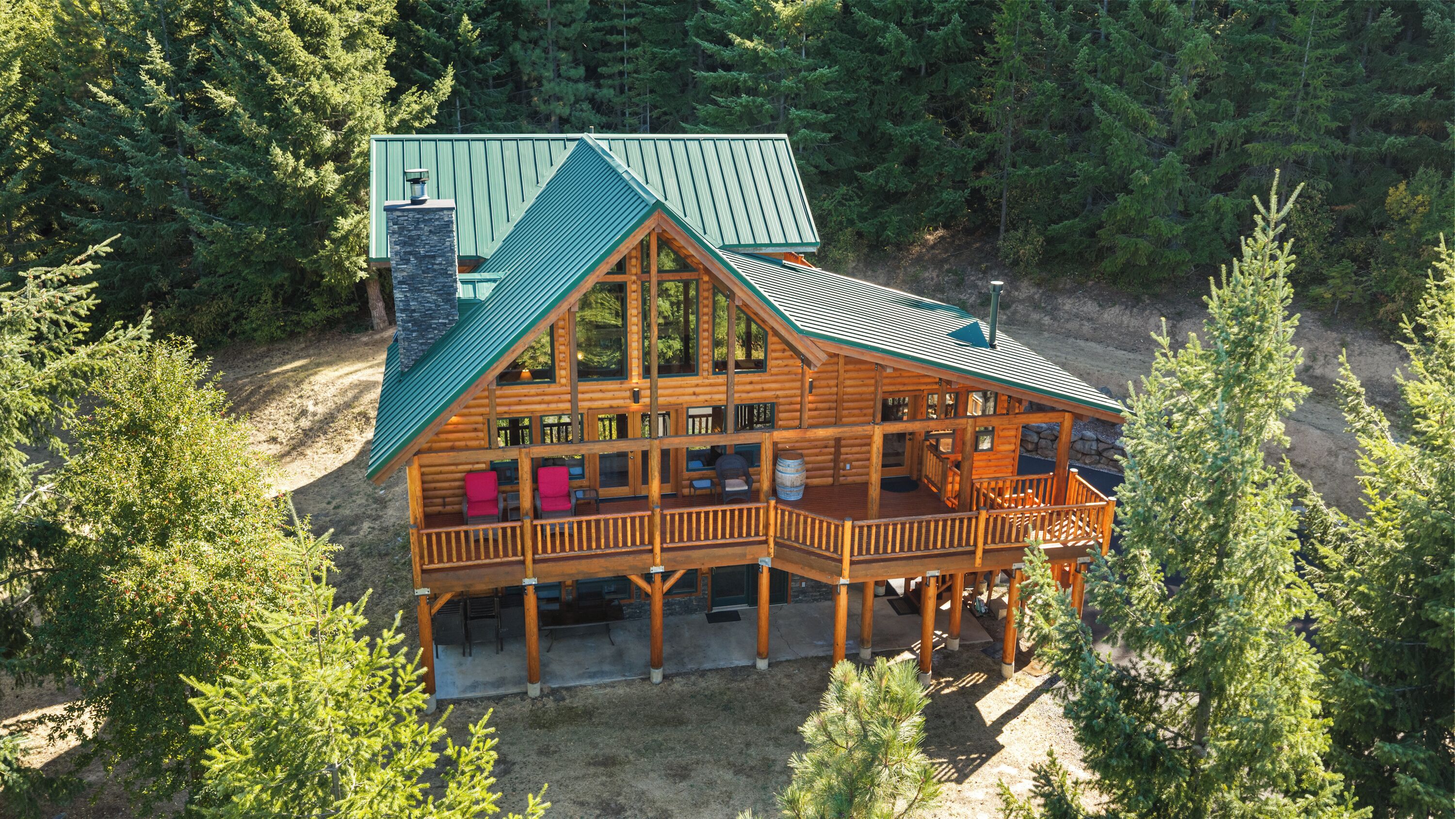 A two-story log cabin with a balcony and a separate garage.