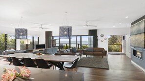 Un vaste espace de vie comprenant une grande table à manger, des sièges confortables et une cheminée.