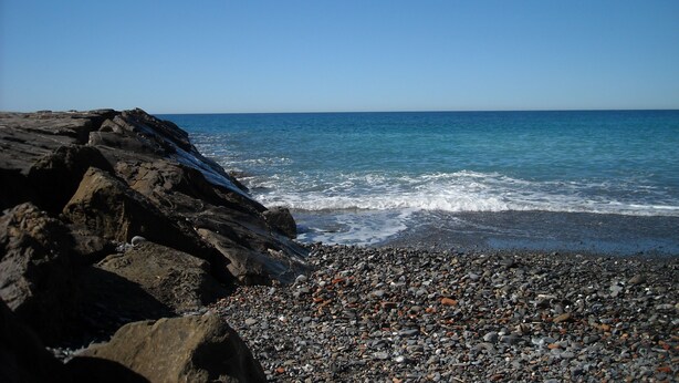 A rocky beach with waves crashing onto the shore.