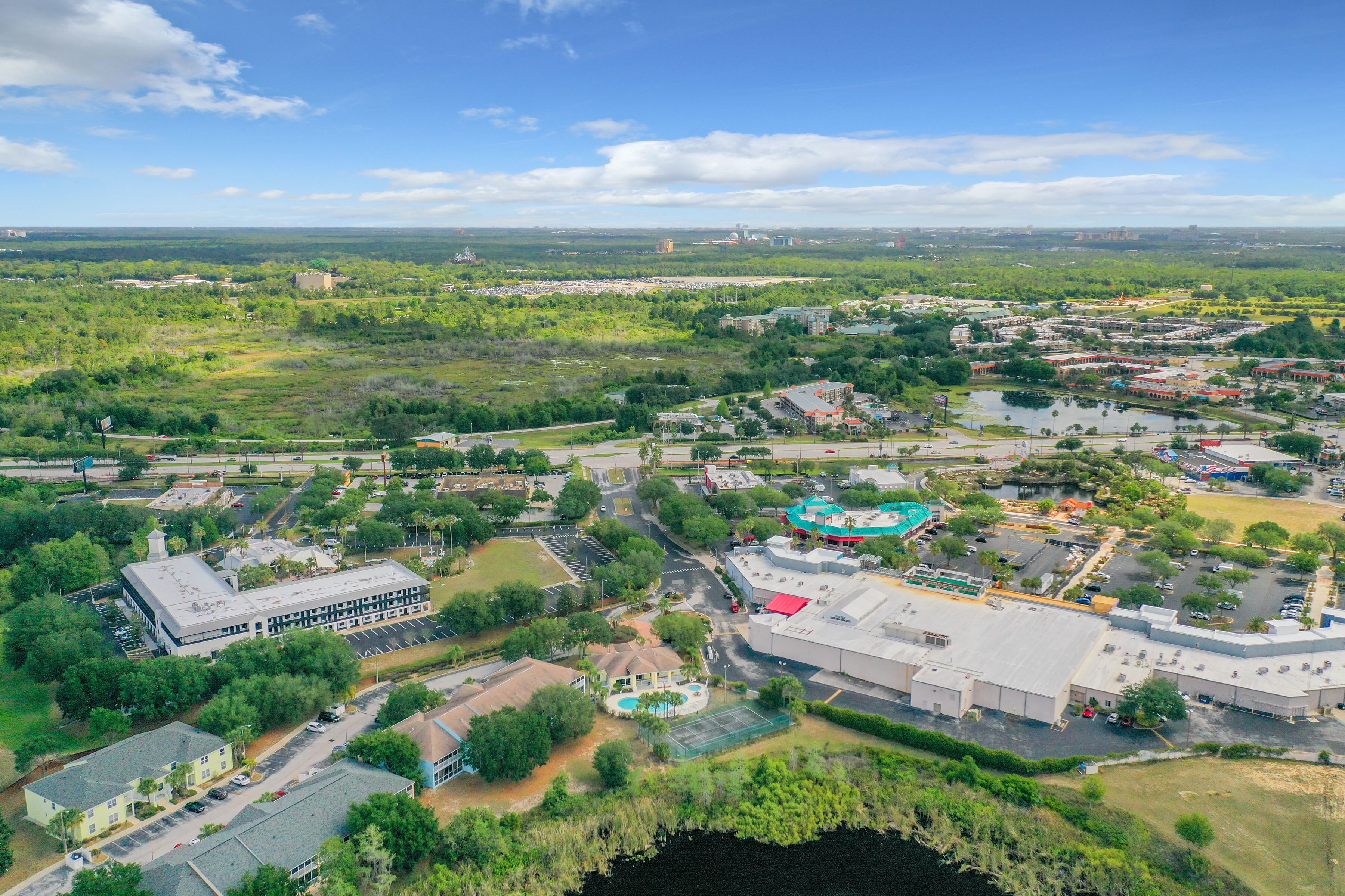 An aerial view of a town with various buildings, roads, and green areas.