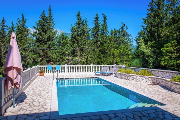 Alberca al aire libre y camastros 