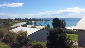 Une propriété située sur la côte, offrant une vue sur la mer, une piscine et un environnement verdoyant.