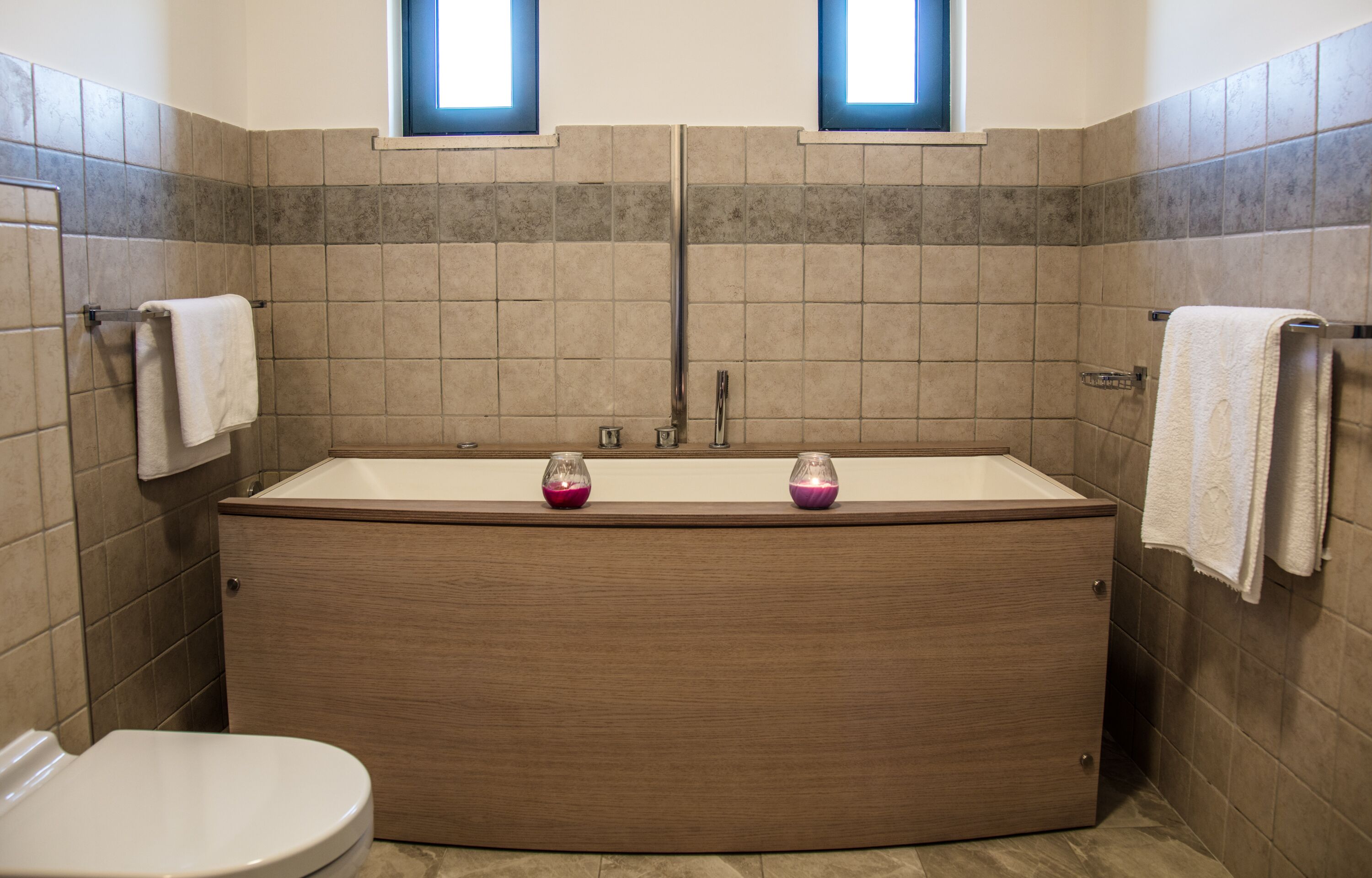 Ein Badezimmer mit einer Holzwanne, zwei Waschbecken und einer Toilette.