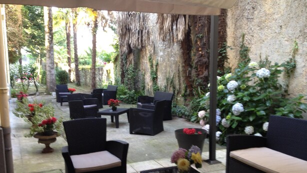 An outdoor seating area with wicker furniture and potted plants. -  BEAUTIFUL 2-ROOM APARTMENT "DESIGN" calm GROUND FLOOR LE LOGIS LE COL D'ASPIN (Lourdes)