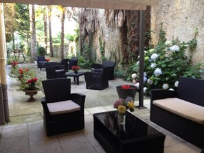 An outdoor seating area with wicker furniture and potted plants. -  BEAUTIFUL 2-ROOM APARTMENT "DESIGN" calm GROUND FLOOR LE LOGIS LE COL D'ASPIN (Lourdes)