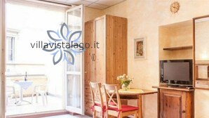 Un salon chaleureux avec un meuble en bois, un téléviseur et un coin repas comprenant une table et des chaises.