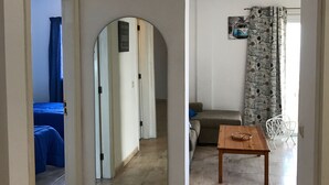 A spacious living area with a large mirror, a wooden table, and a sofa. - Front line apartment in Puerto Santiago-Los Gigantes with beautiful views.<br> (Puerto Santiago)