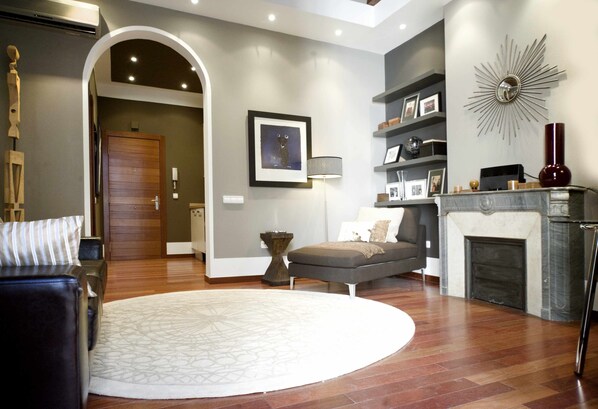 Un salon moderne avec une cheminée, un tapis rond et un canapé.
