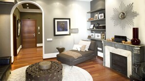 A modern living room with a sofa, a fireplace, and a decorative wall piece.
