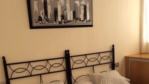 A double bed with a patterned bedspread and pillows, a black metal headboard, and a framed cityscape artwork on the wall. - BEAUTIFUL MEDITERRANEAN AVENUE APARTMENT (Benidorm)